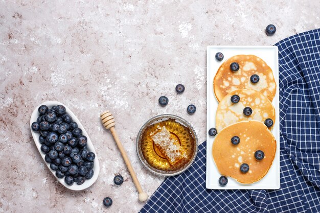 Blueberry pancakes on brown light surface