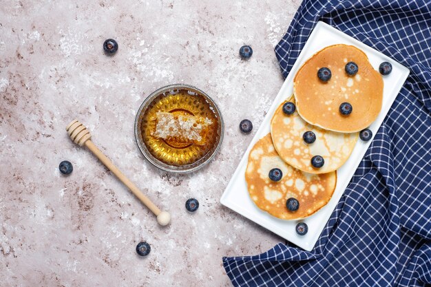 Blueberry pancakes on brown light surface