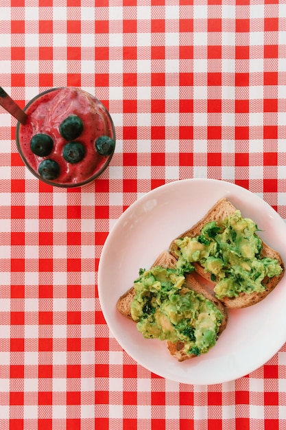 Foto gratuita frullato di mirtilli e toast di avocado