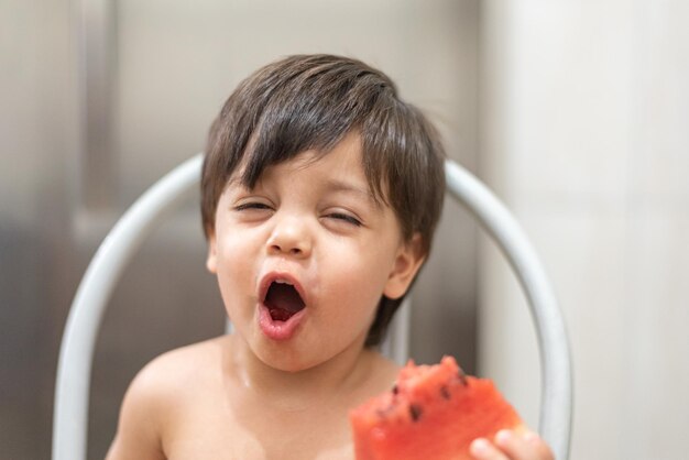 Голубоглазый мальчик ест арбуз