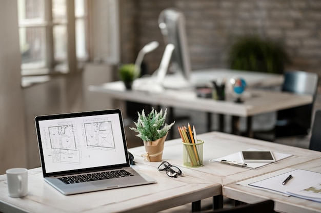 Blueprints on computer monitor at the desk in real estate office