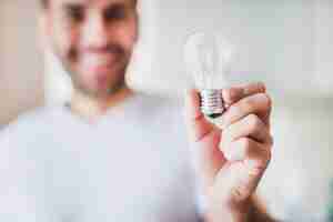 Free photo blur man showing transparent light bulb