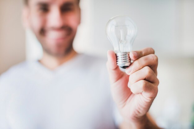 Blur man showing transparent light bulb