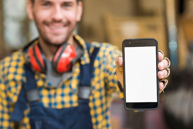 Blur portrait of a male carpenter showing his smartphone displaying white screen