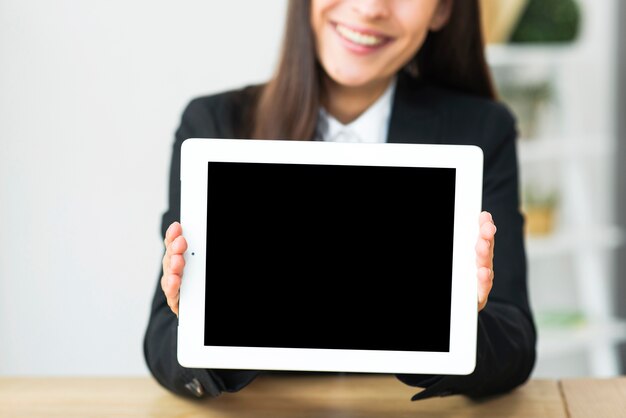 Blur smiling businesswoman showing blank screen display on digital tablet