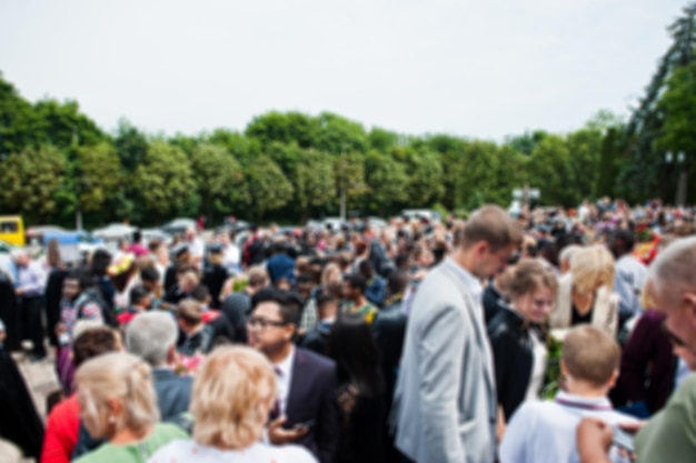 Free photo blured photo of graduates and their parents or friends are waiting for the prom ceremony outside