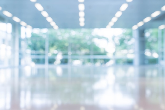 Blurred abstract background interior view looking out toward to empty office lobby and entrance doors and glass curtain wall with frame