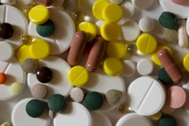 Размытый фон таблеток разных цветов и размеров, вид сверху
