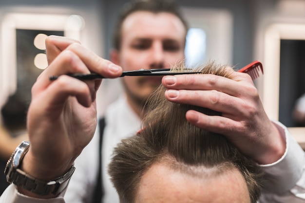 Blurred barber cutting hair of customer