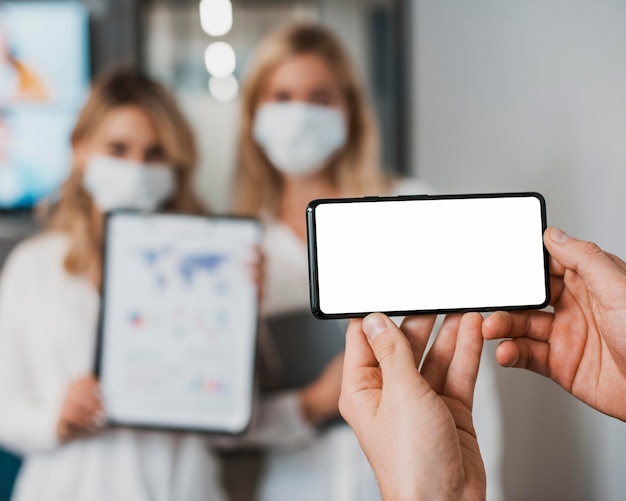 Free photo blurred beautiful businesswomen wearing masks