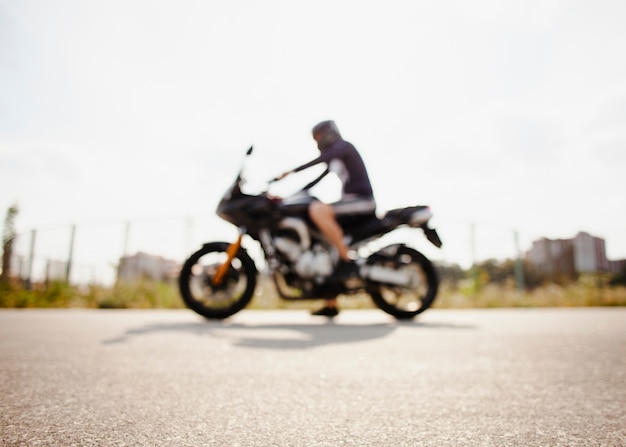 Blurred biker parked on the road