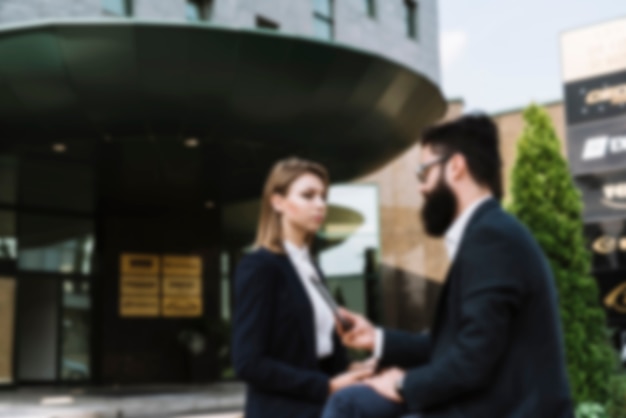 Free photo blurred businesspeople standing in front of office building