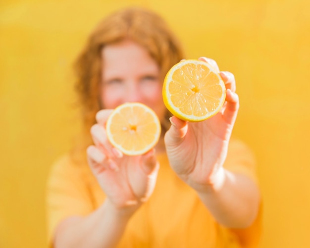 Затуманенное девушка держит лимоны