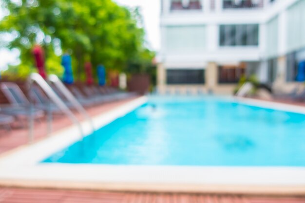 Blurred hammocks with colorful umbrellas in a pool