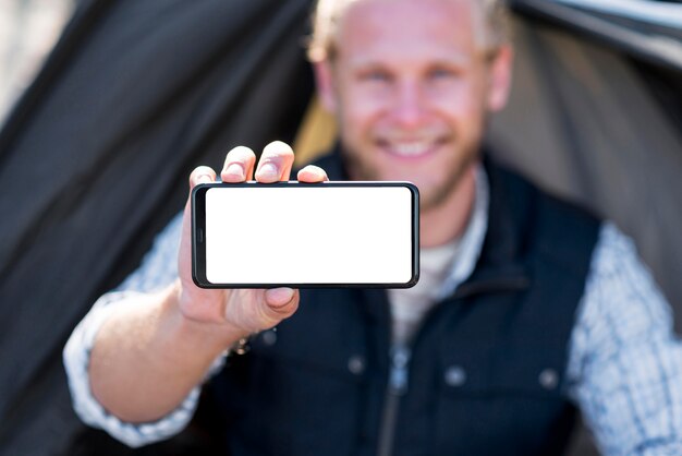 Blurred man holding horizontal copy space mobile phone