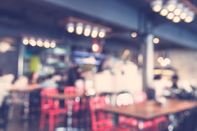 Free photo blurred restaurant with red chairs