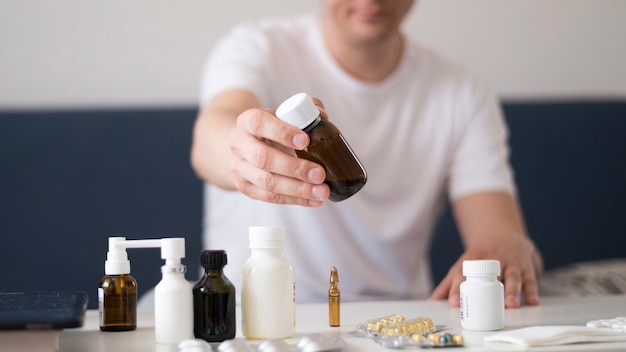 Blurred sick man holding a glass container