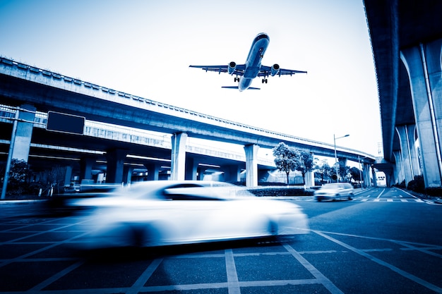 Sfocata scena di strada in città con un aereo che vola sopra