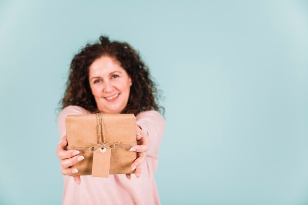 Free photo blurred woman showing gift