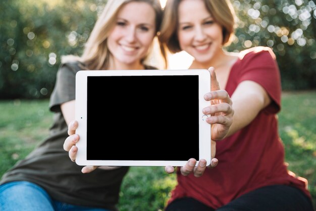 Blurred women showing tablet