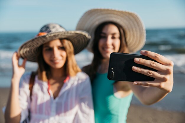 Blurred women taking selfie at the beach