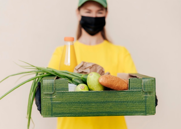 食品箱を保持しているぼやけた配達の女性