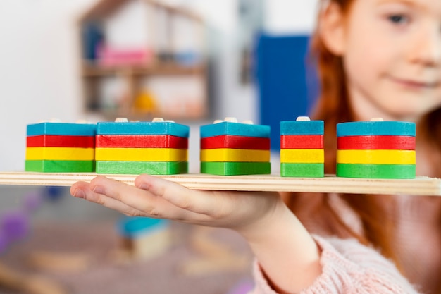 Free photo blurry girl holding wooden toy