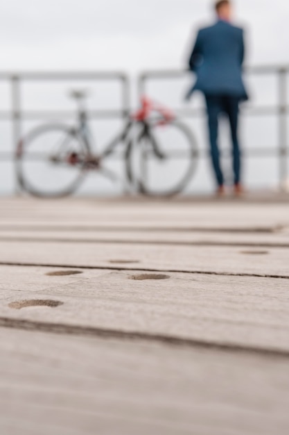 Uomo sfocato in costume in piedi accanto a una bicicletta