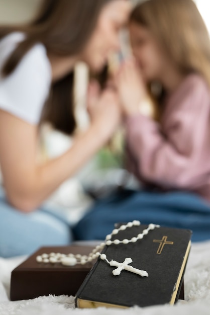 Blurry mother and girl praying together