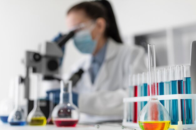 Blurry woman looking through microscope