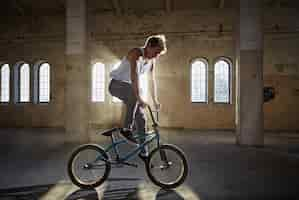 Free photo bmx stunt and jump riding in a sunlight, indoor park.