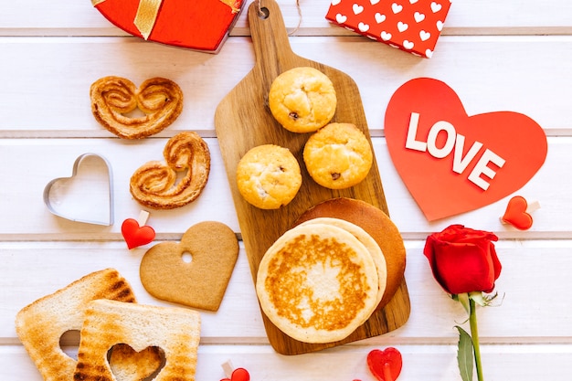 Tavola con pasta da forno vicino al cuore e rosa