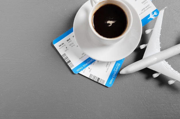 Boarding pass and toy airplane on table top view