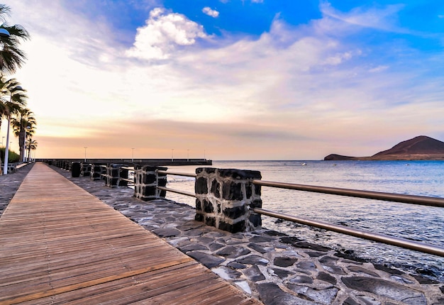 Foto gratuita passerella in riva al mare sotto un bel cielo nuvoloso nelle isole canarie, spagna