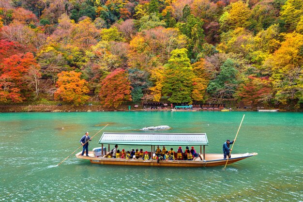 Boatman punting the boat at river. Arashiyama in autumn season along the river in Kyoto, Japan