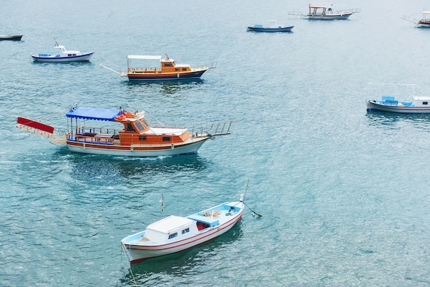 Boats float in the calm blue sea water in Turkey.