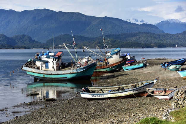 Boats parked on the lakeshore with mountains