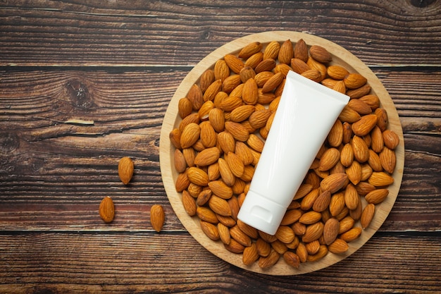 Body almond moisturizer on dark wood background