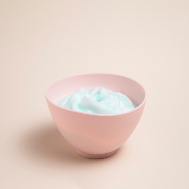 Body care foam in a bowl with plain background