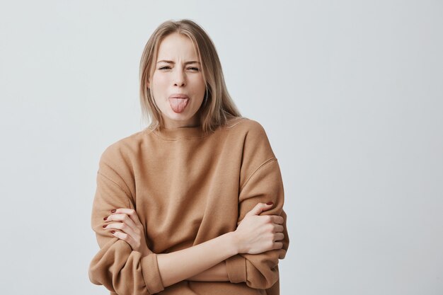 Body language. Naughty stressed beautiful woman with straight fair hair posing