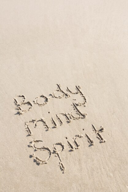 Body mind spirit written on sand