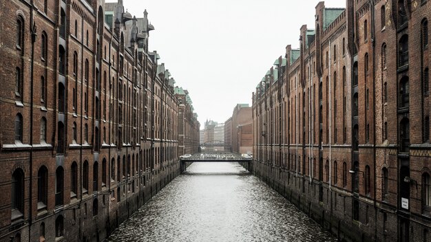 낮 동안 독일 함부르크에있는 갈색 콘크리트 건물 사이의 수역