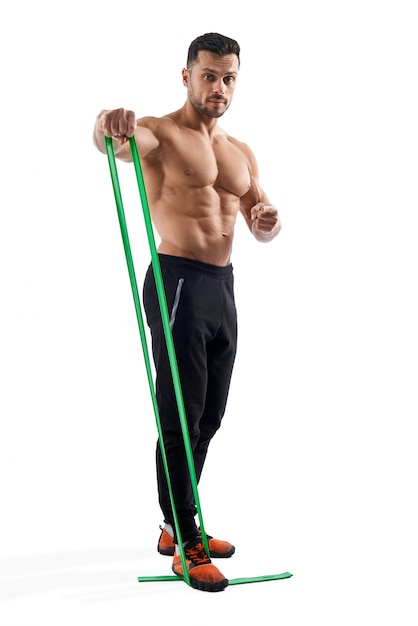 Bodybuilder training shoulders using resistance band.