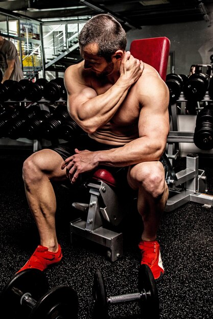 Bodybuilder warming up before training in a gym.