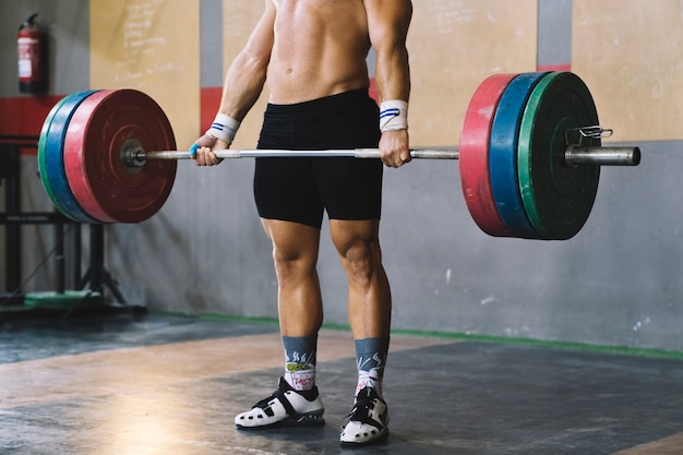 Bodybuilding concept with man holding barbell