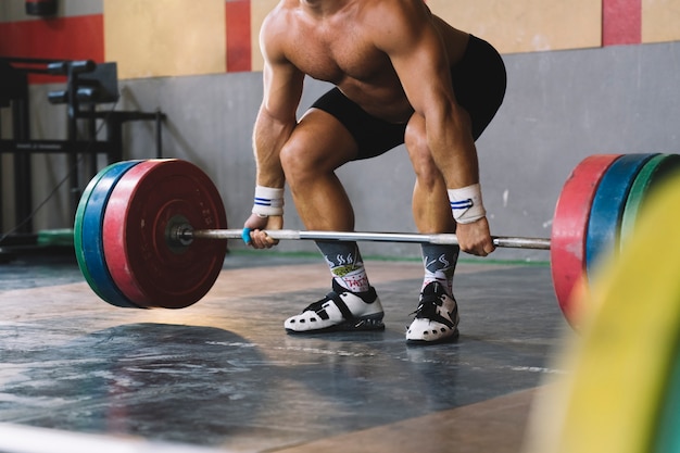 Bodybuilding concept with strong man holding barbell