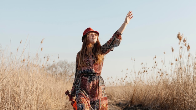 Bohemian woman in nature holding ukulele