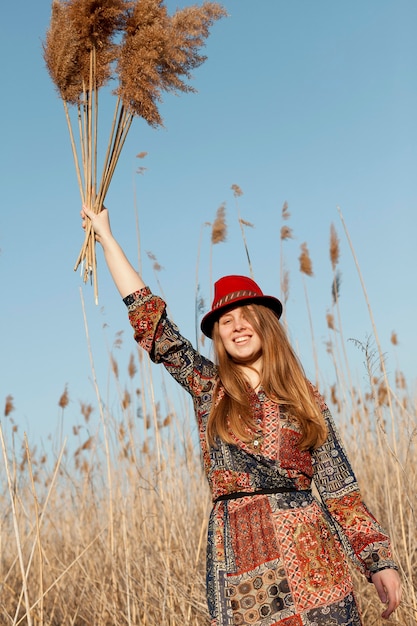 Bohemian woman posing with dead grass