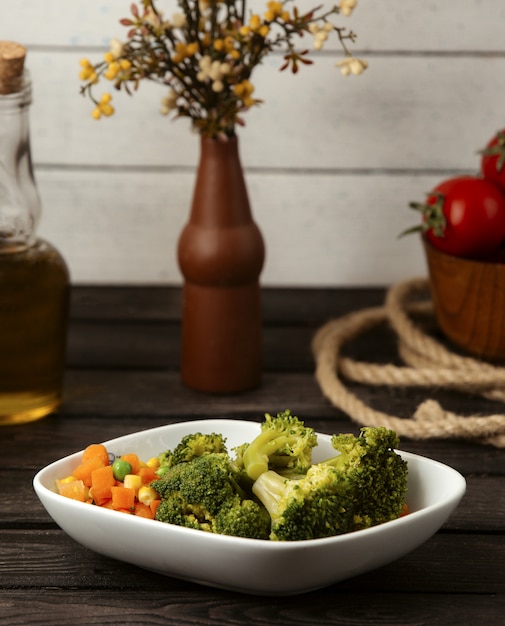 Free photo boiled broccoli carrots and corn on a wooden table