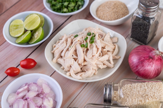 Boiled chicken cut into pieces in a white dish on a wooden table.